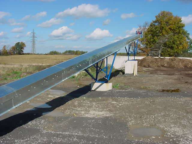 FDI high speed manure conveyor running from a barn to a storage building